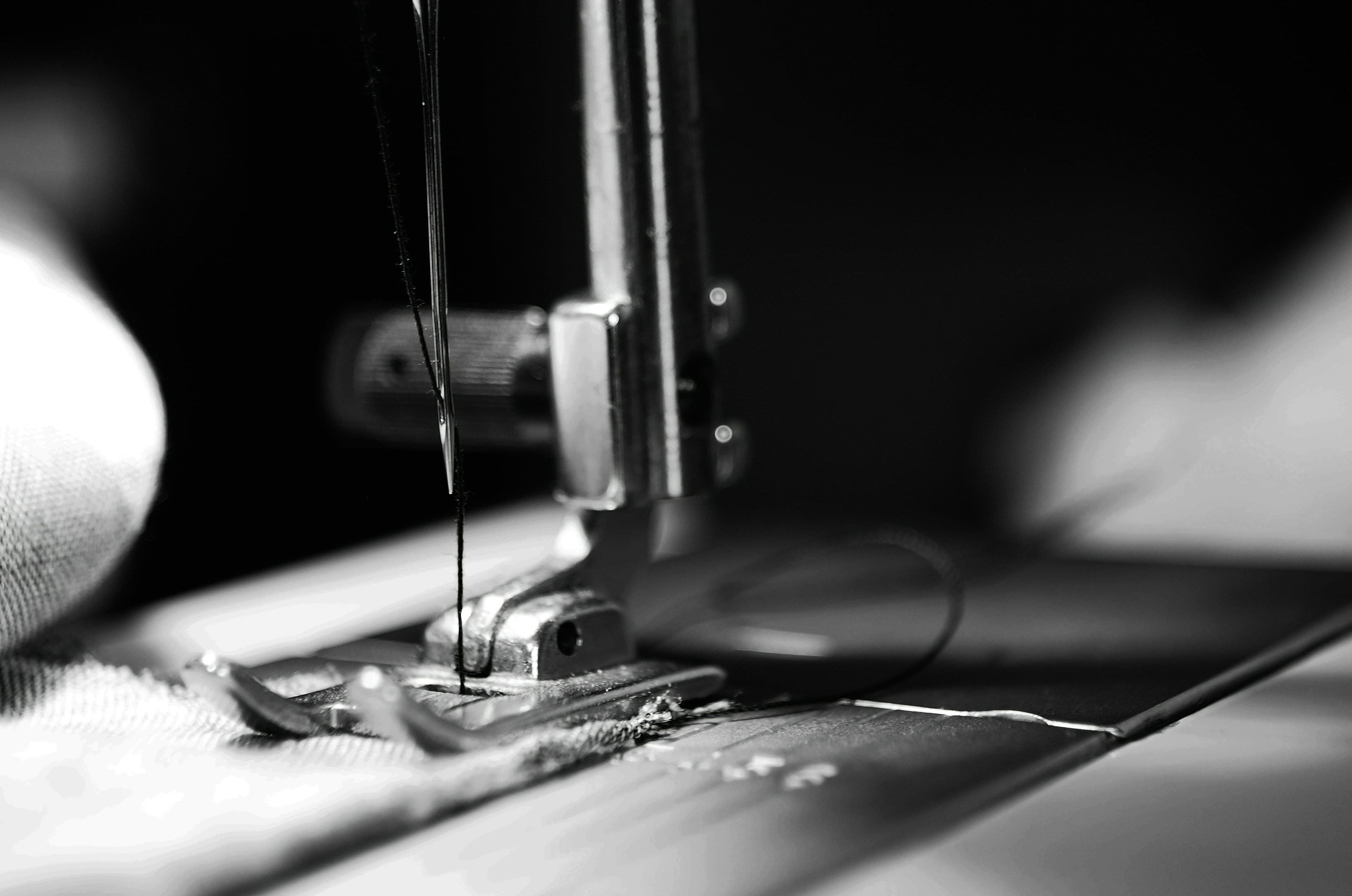 Close-up of an industrial sewing machine needle stitching a garment