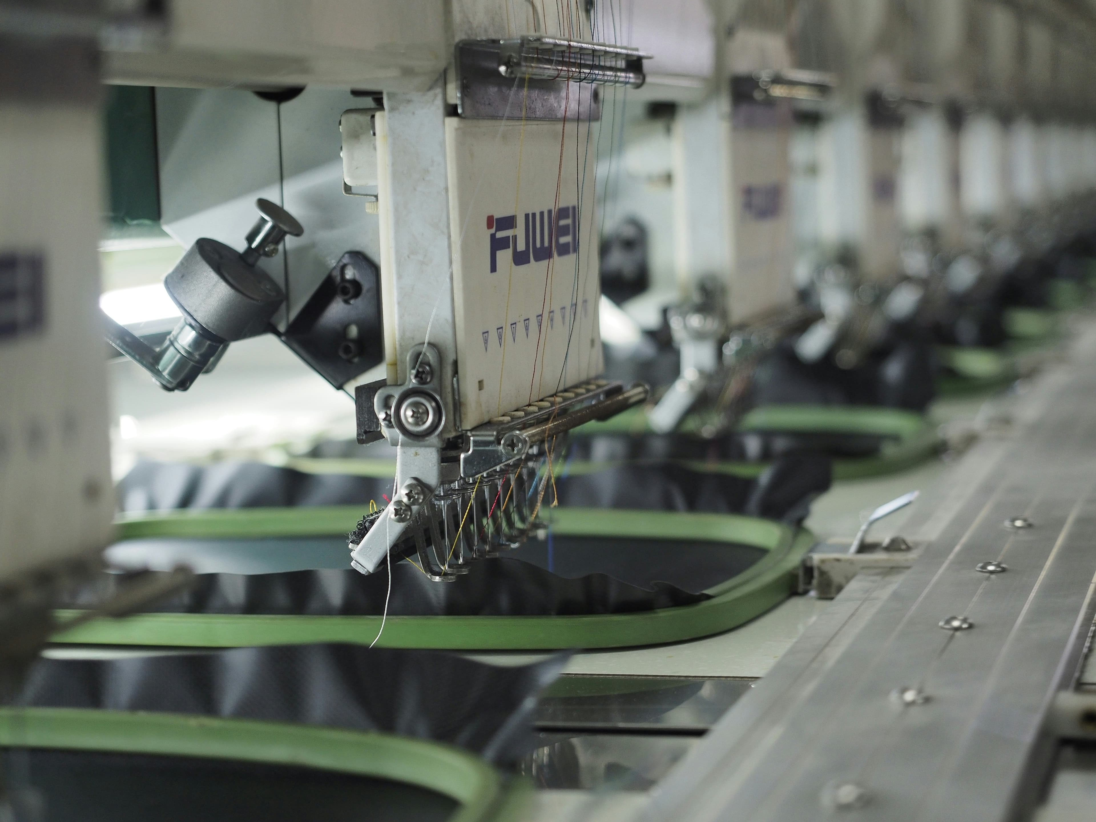 Multi-head industrial embroidery machine stitching a logo into a garment